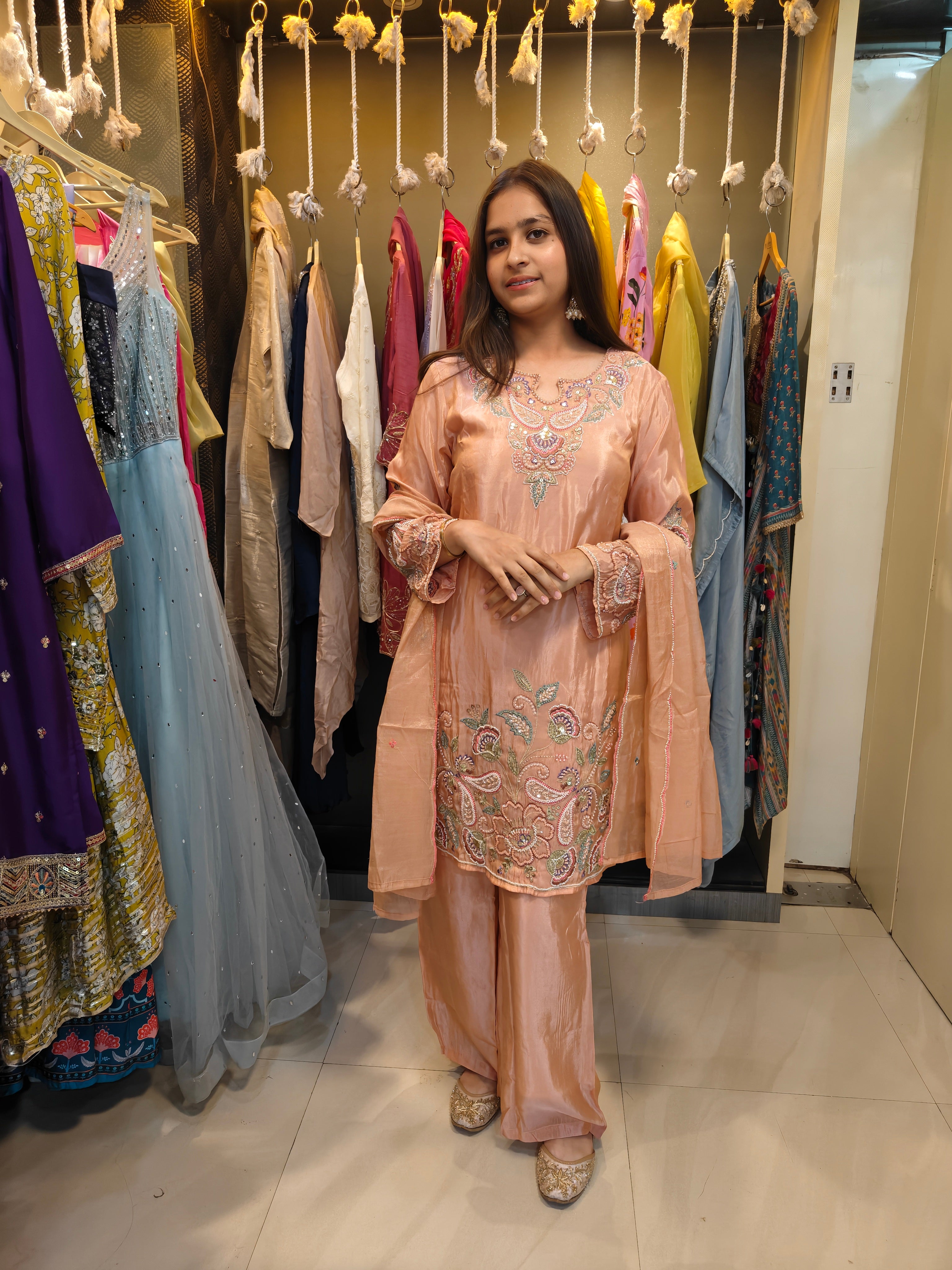 Front view of peach hand-embroidered tissue kurta with pastel threadwork